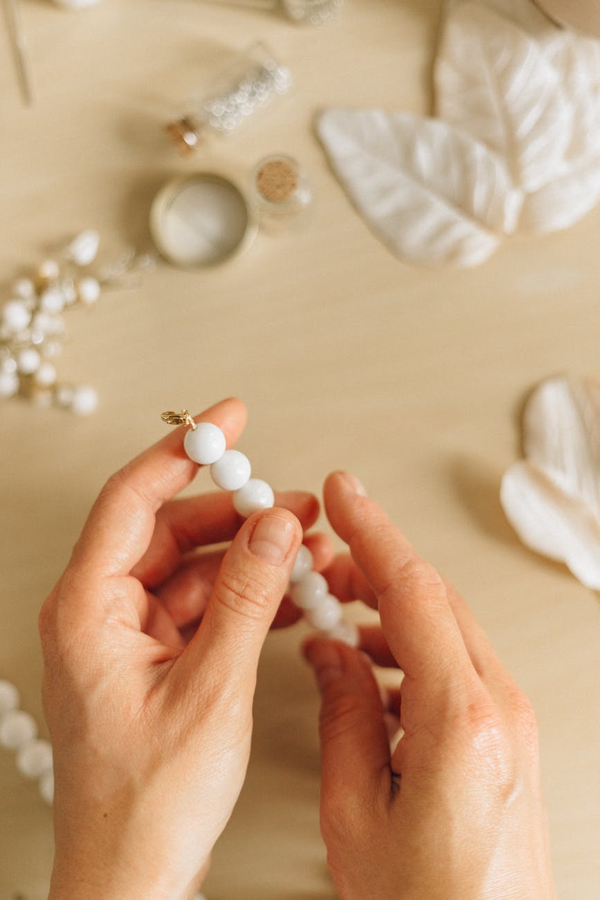 person holding white pearl beads