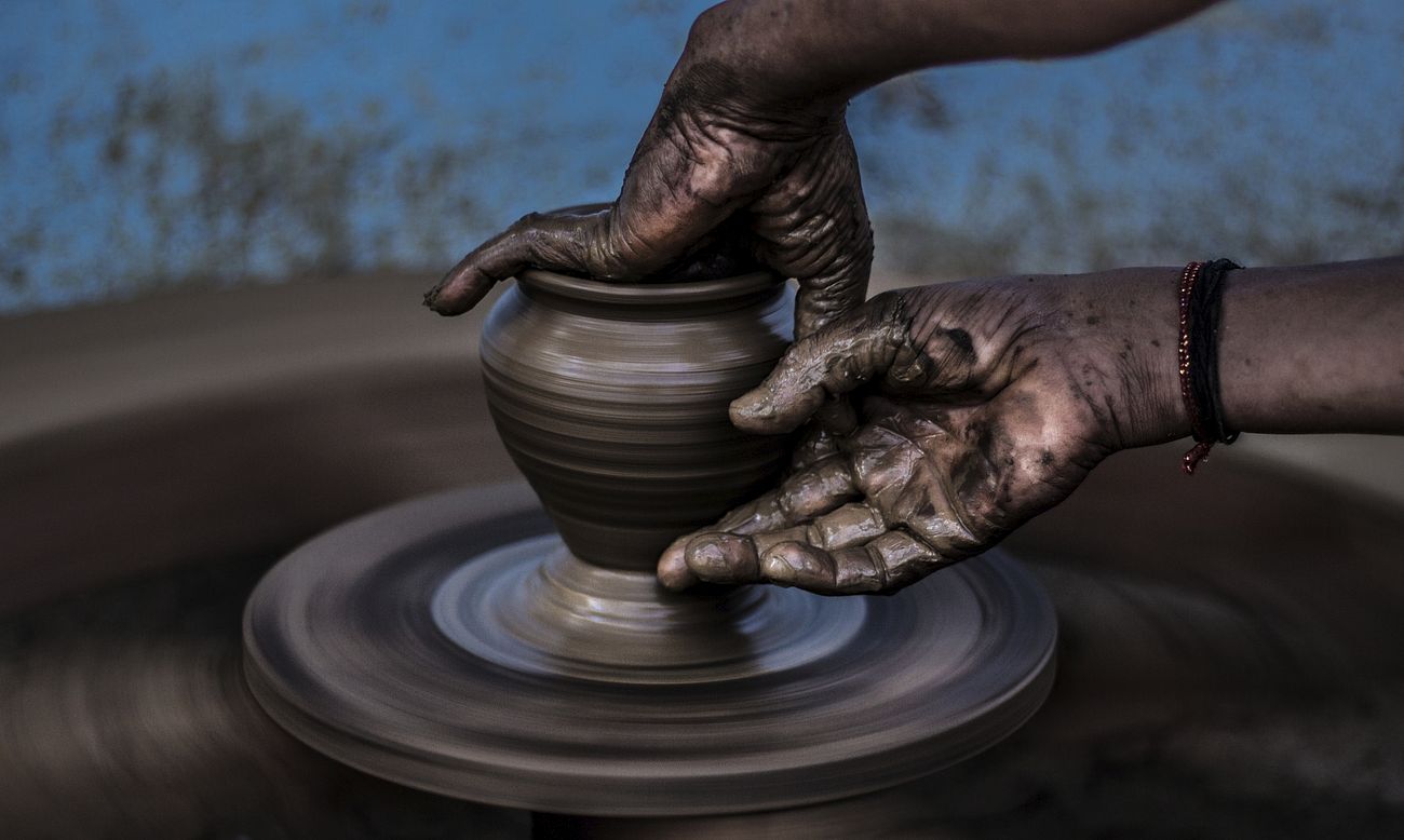 Hands create art on a pottery