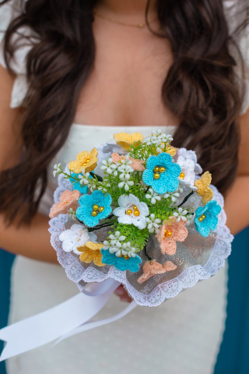 a bride holding a bouquet of crocheted flowers