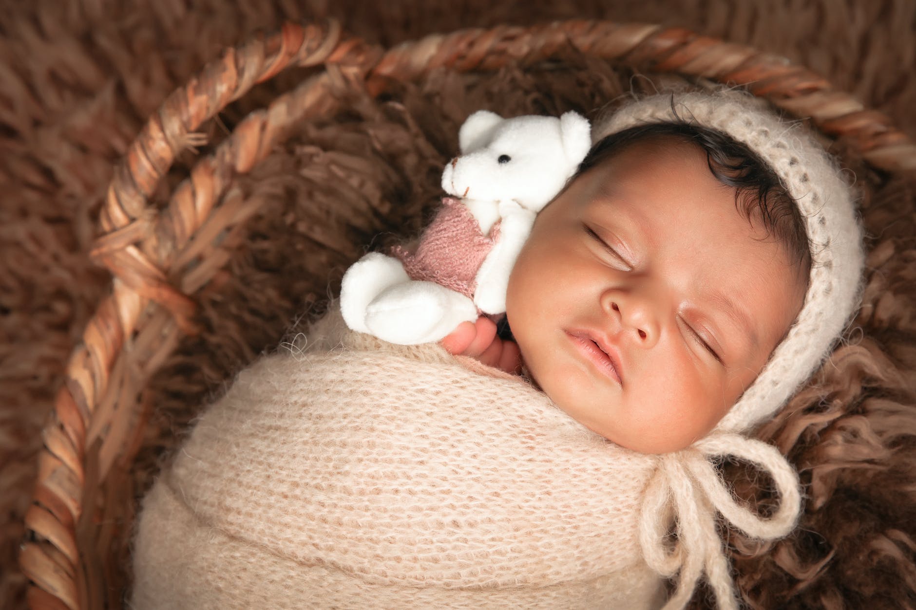 a newborn baby wrapped in a blanket lying in a basket
