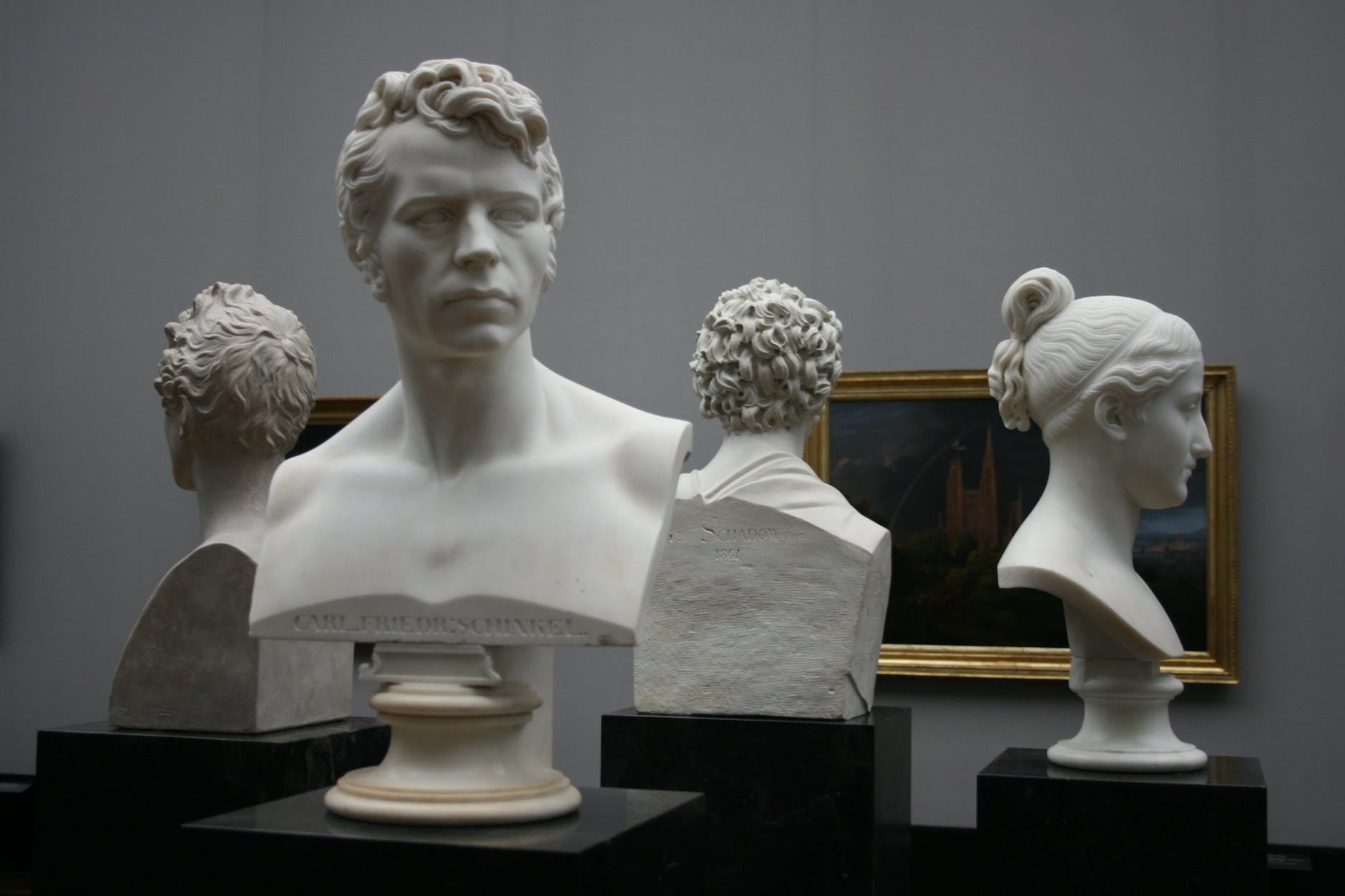men and woman head busts