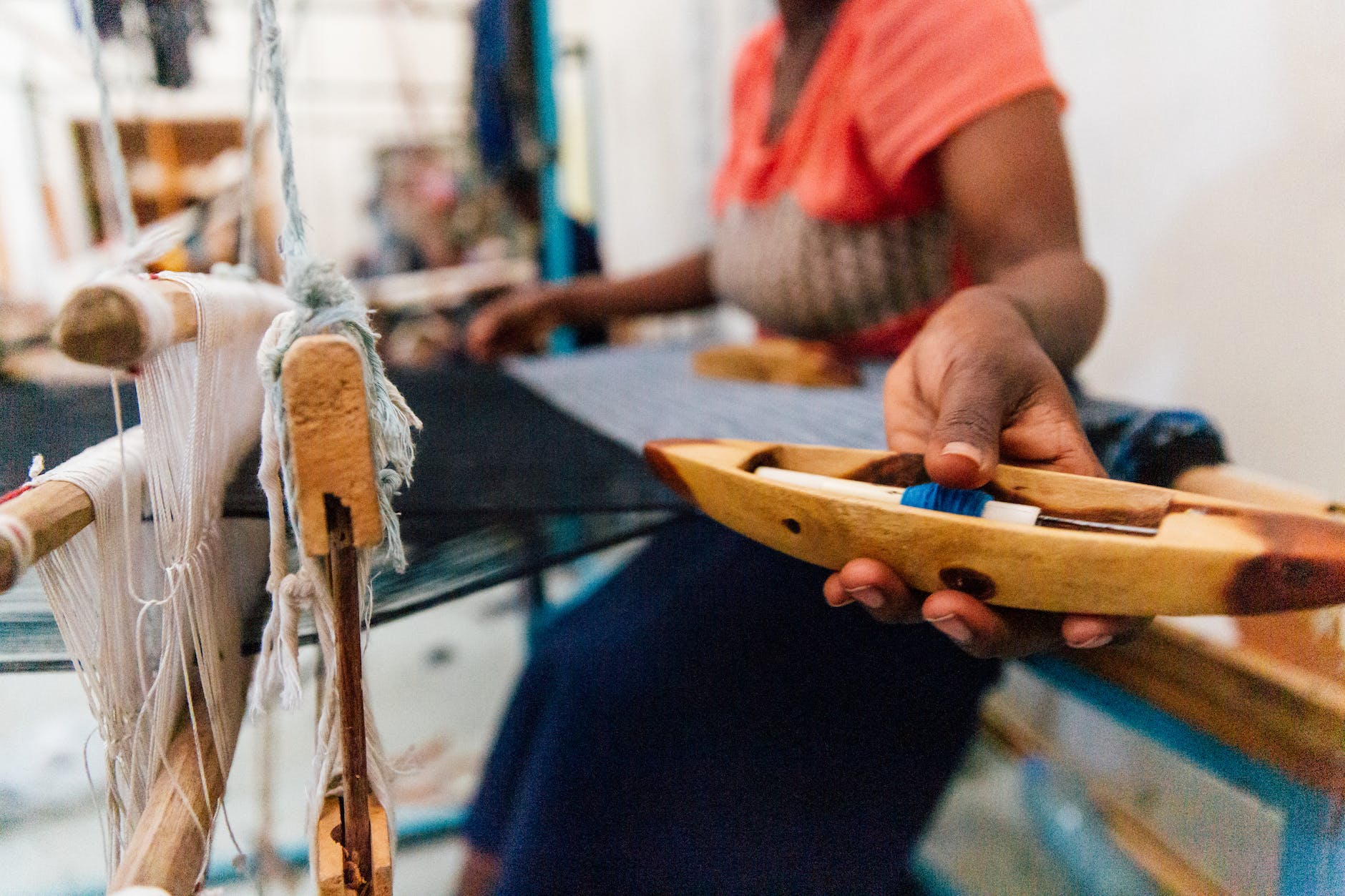 crop black female artisan working on manual loom in workshop