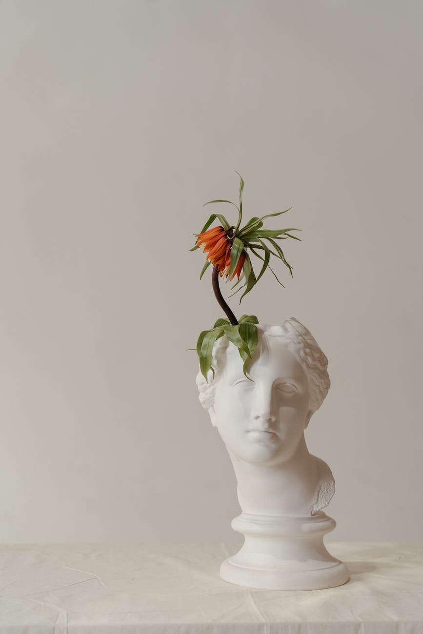 white ceramic woman with orange flower on head bust