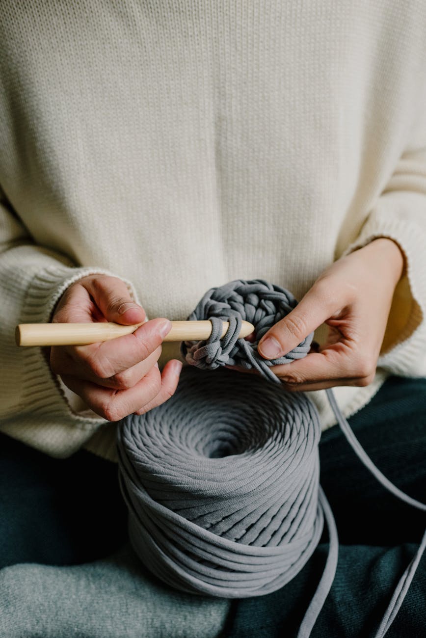 person in holding gray yarn
