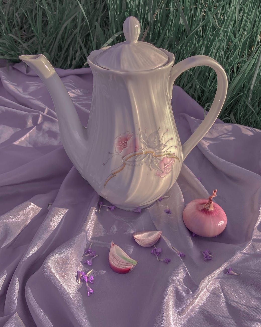 ceramic teapot and onion on silk cloth