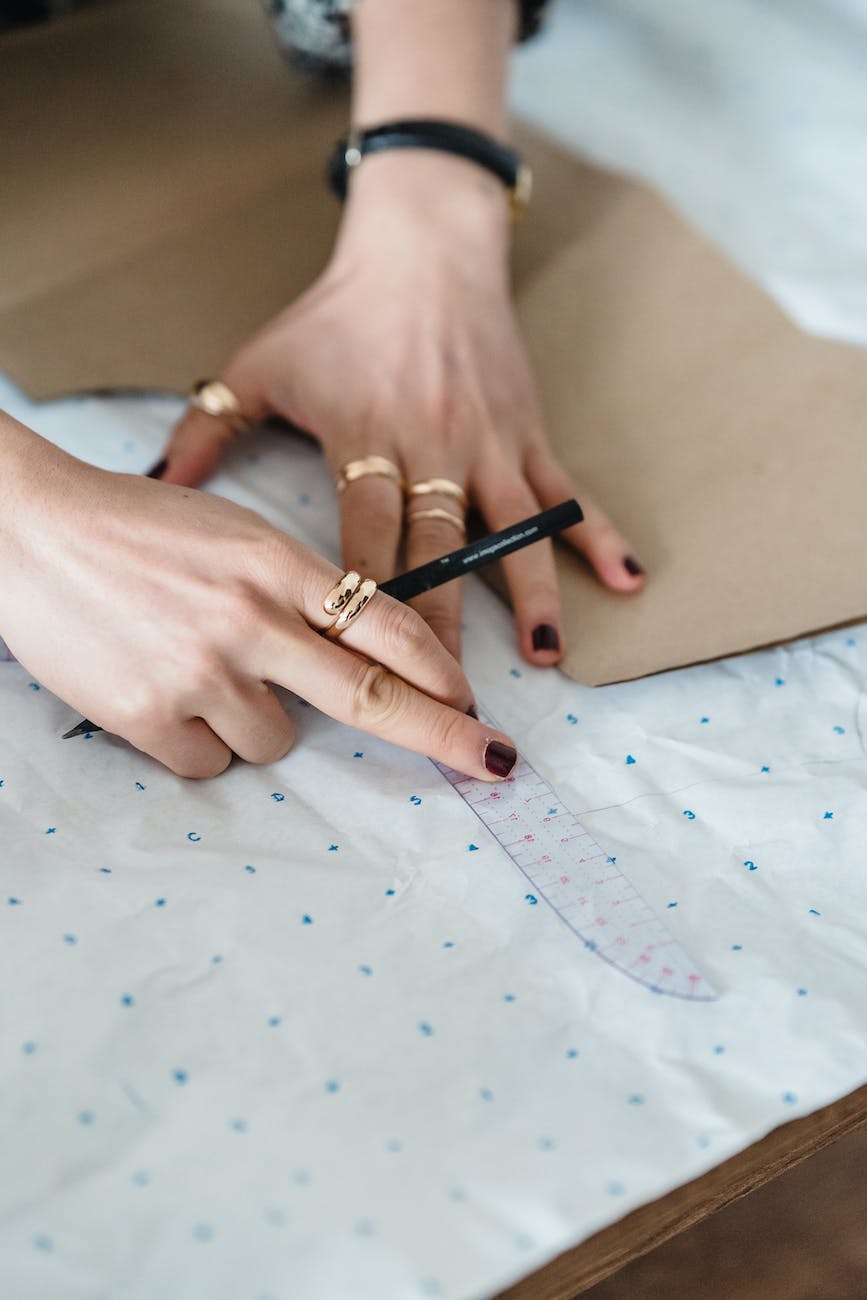 crop seamstress with sewing ruler and pattern on paper