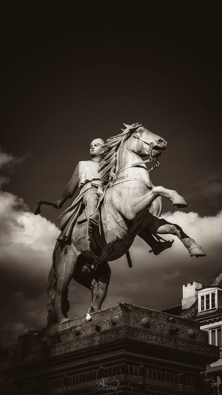 man holding axe rides on horse concrete statue