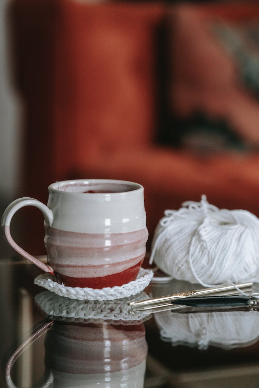 a ceramic cup near the white yarn