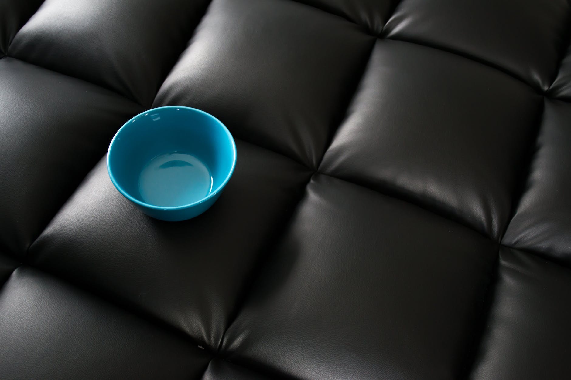 blue ceramic bowl on black leather surface